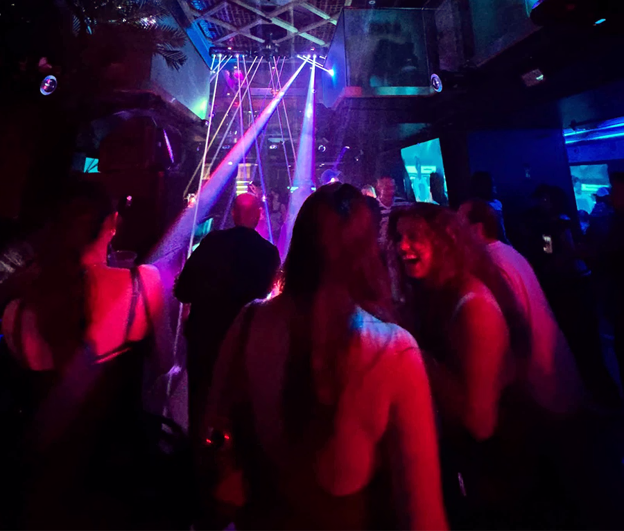 Guests dancing under colorful lights during Intimate House Sessions at Masada